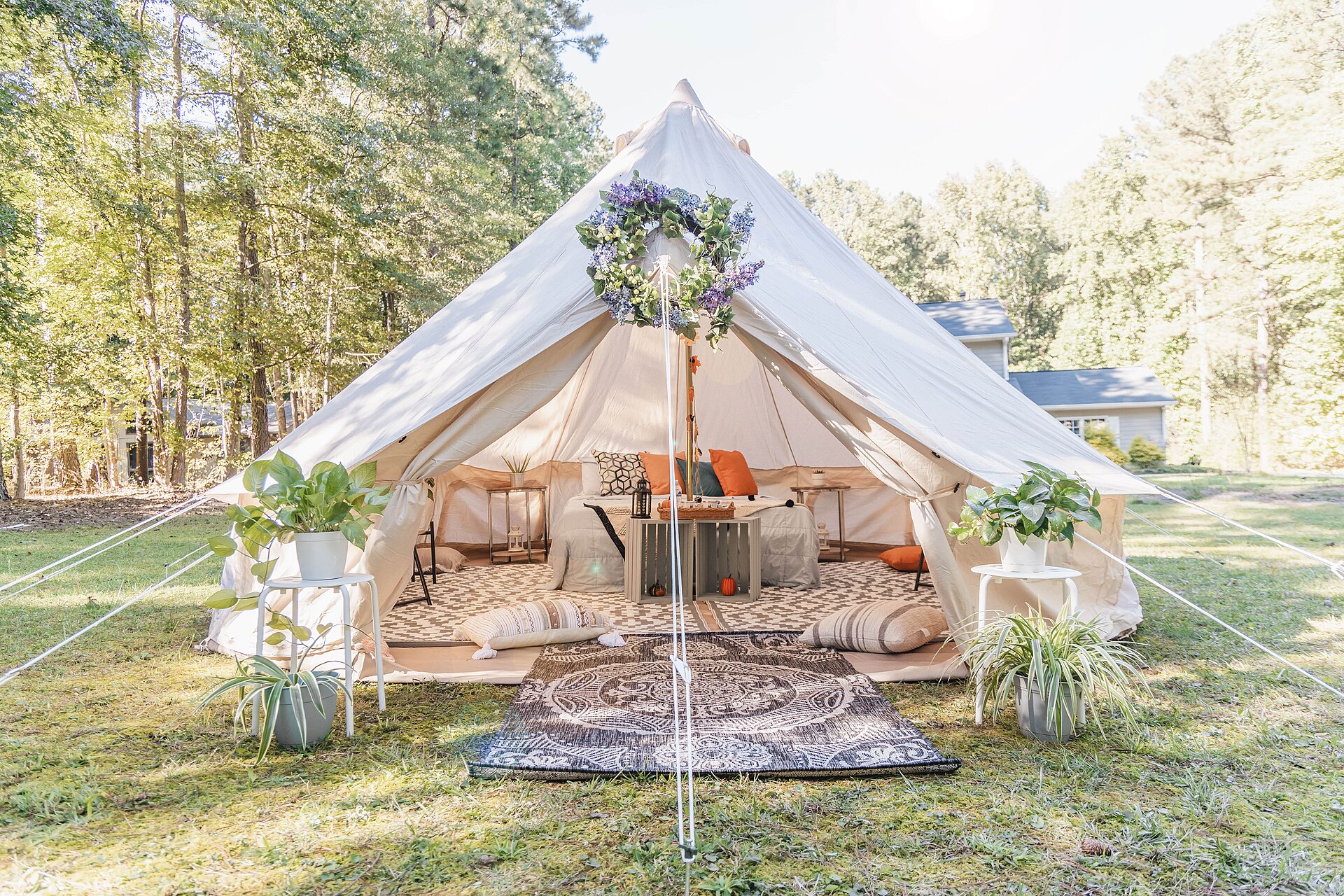 Tienda campana de glamping amueblada, con alfombras y cama