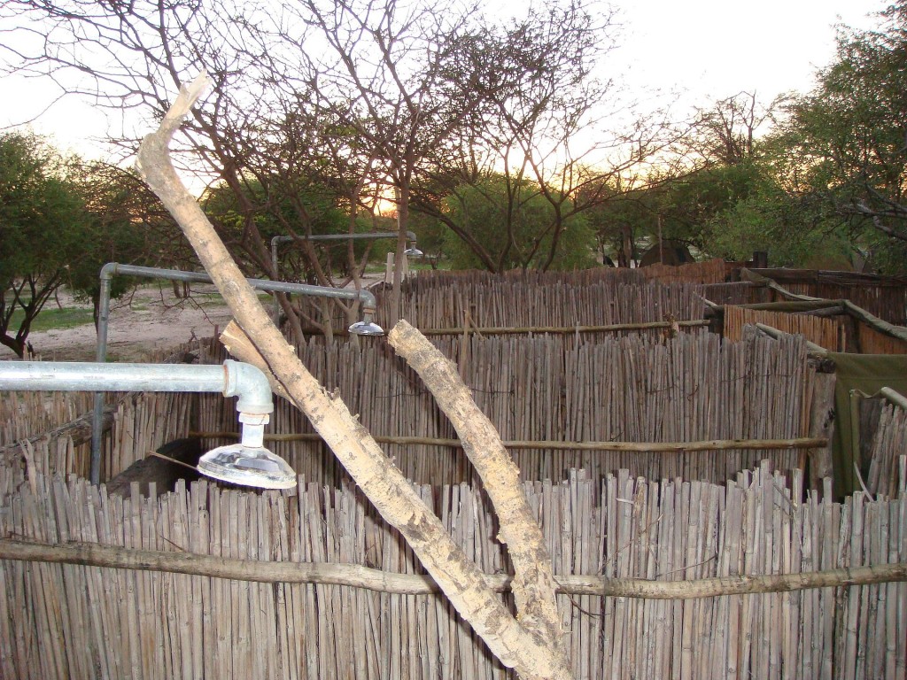 Ducha exterior de un camping con cerramiento de cañizo