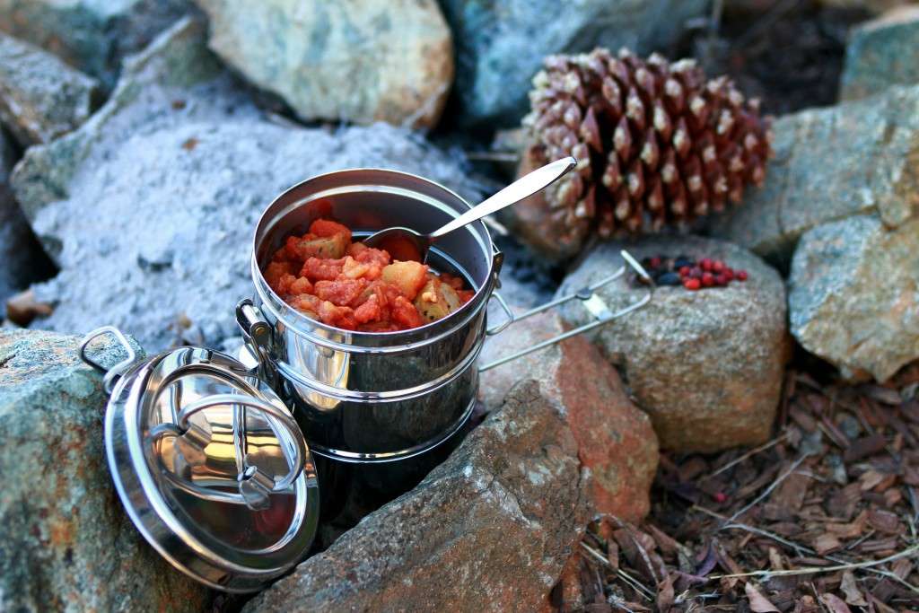 Fiambrera de acero con comida en un campamento